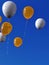 Floating helium balloons with ribbons on blue sky