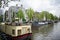 Floating homes, barge boats on the canal in Amsterdam with the beautiful backdrop of Amsterdam