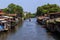 Floating houses on both sides of the canal under blue sky