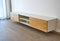 Floating media cabinet in contemporary living room. Wooden wall mounted cabinet