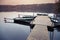 Floating pier with moored row boats, still lake