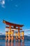 Floating red giant Grand O-Torii gate stands in Miyajima island bay beach