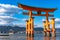 Floating red giant Grand O-Torii gate stands in Miyajima island bay beach