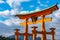 Floating red giant Grand O-Torii gate stands in Miyajima island bay beach