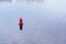 Floating red navigational buoy on blue water of Dnipro River. Buoy in the river. Navigation equipment.