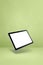 Floating tablet pc computer isolated on green. Vertical background