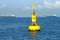 Floating yellow navigational buoy on blue sea