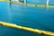Floating yellow and white oil containment boom on calm water. Pollution concept . A containment boom is a temporary floating