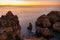 Flock of birds soaring in the sky above Ponta da Piedade at sunset