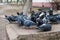 A flock of blue-gray pigeons eats grain on a stone pedestal in the city Park