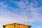 A flock of Laundress birds on a TV antenna against stunning blue sky with clouds