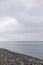 A flock of migratory birds flying wedge over the sea. Cloudy weather. Selective focus.