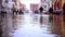 Flood water against citizens walking in special rubber boots