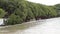 Flood, Water flow over road, tree line background.