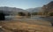 Flooded banks of the spring of the river with an island in the middle of the channel surrounded by mountains