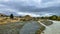 Flooded creek on the winding narrow gravel road between Lake Tekapo and Lake Pukaki in rural agricultural land