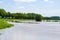 Flooded Dutch polder area next to a dike overgrown with grass. Flood in Limburg in July 2021