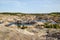 Flooded quarry with lakes and dried hills with rare vegetation.