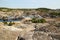 Flooded quarry with lakes and dried hills with rare vegetation.