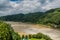 Flooded river under cloudy sky after torrential rains