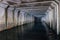 Flooded sewer tunnel is reflecting in water. Dirty urban sewage flowing throw rectangular sewer tunnel