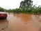 Flooded street in a district of dschang, users walk in water