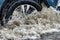 Flooding in the city after the rain. The car drives through a puddle in the pouring rain. Splashes of water from under the wheels