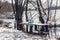 Flooding in early spring. Garbage in a bag in the woods. Flooded table with benches near the pond