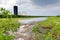 Flooding rain water flowing through farm field waterway.