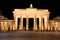 The floodlit Brandenburg Gate in Berlin with a few fleeting shad