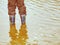 Floody river. Brown water of rised river. Child in rubber boots