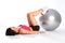 Floor exercise with ball by beautiful woman in gym