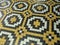 Floor of yellow black and white tiles forming crosses and a moving pattern