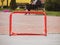 Floorball goal. Children playing outdoor in spring. Floor hockey players goalkeeper running with ball and sticks