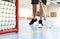 Floorball player. Floor hockey and indoor bandy game. White ball and stick. Goal and net on the floor in training arena.