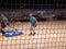 Floorball players in the indoor playground. A view through net