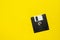 Floppy data storage diskette on yellow background with copy space