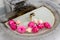 Floral arrangement of pink roses in the basin of an old stone fountain