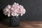 Floral beautiful artistic still life, design and interior details. Artificial pink hydrangea in a black ceramic vase on a wooden