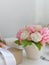 Floral bouquet in ceramic vase on white background.