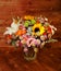 Floral bouquet with lily, sunflower, chrysanthemum, eustoma lisianthus astrantsiya, eucalyptus, shrub rose on wooden board