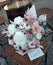 Floral bunch in round box. Bouquet in peach color of beautiful preserved flowers. White rose , mixed roses flowers, dried palm