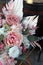 Floral bunch in round box. Bouquet in peach color of beautiful preserved flowers. White rose , mixed roses flowers, dried palm