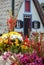 A floral composition with tropical flowers and a traditional house from Santana in the background. Madeira