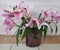 Floral display including Flashpoint pink and white Oriental Trumpet Lily in a transparent vase