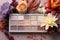 Floral elegance meets beauty Eyeshadow palette and flowers on white, text friendly space