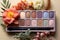 Floral elegance meets beauty Eyeshadow palette and flowers on white, text friendly space