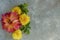 Floral flat lay of chrysanthemums and dahlias and green leaves. Top view and copy space on gray background