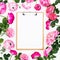 Floral frame with pink flowers and clipboard with copy space on white background. Flat lay, top view. Floral pattern of pink