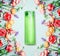 Floral natural cosmetic product and beauty concept. Green Bottle with and flowers on shabby chic background
